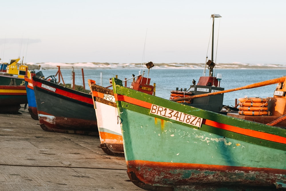 green and red boat on beach shore during daytime