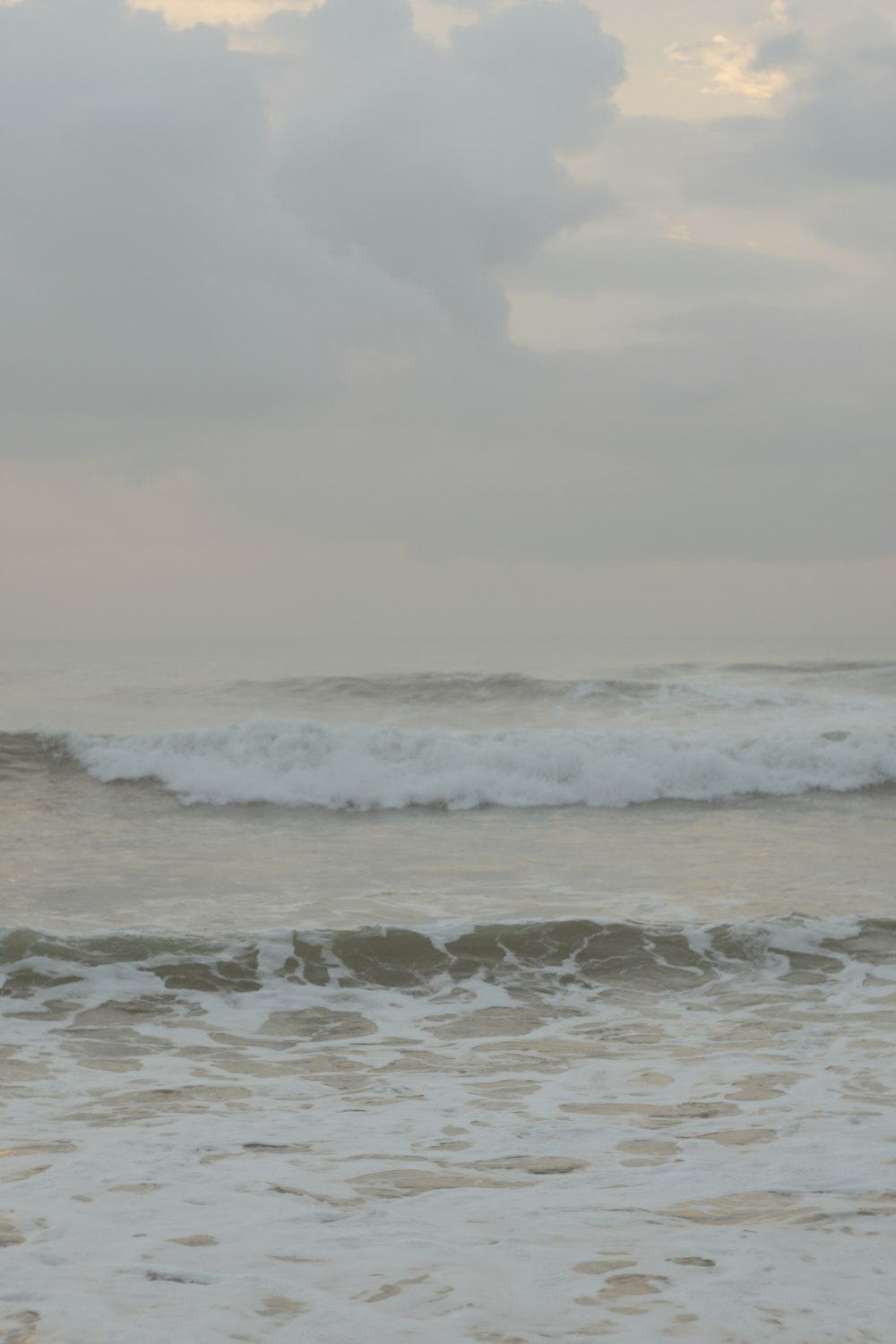 ocean waves under cloudy sky during daytime