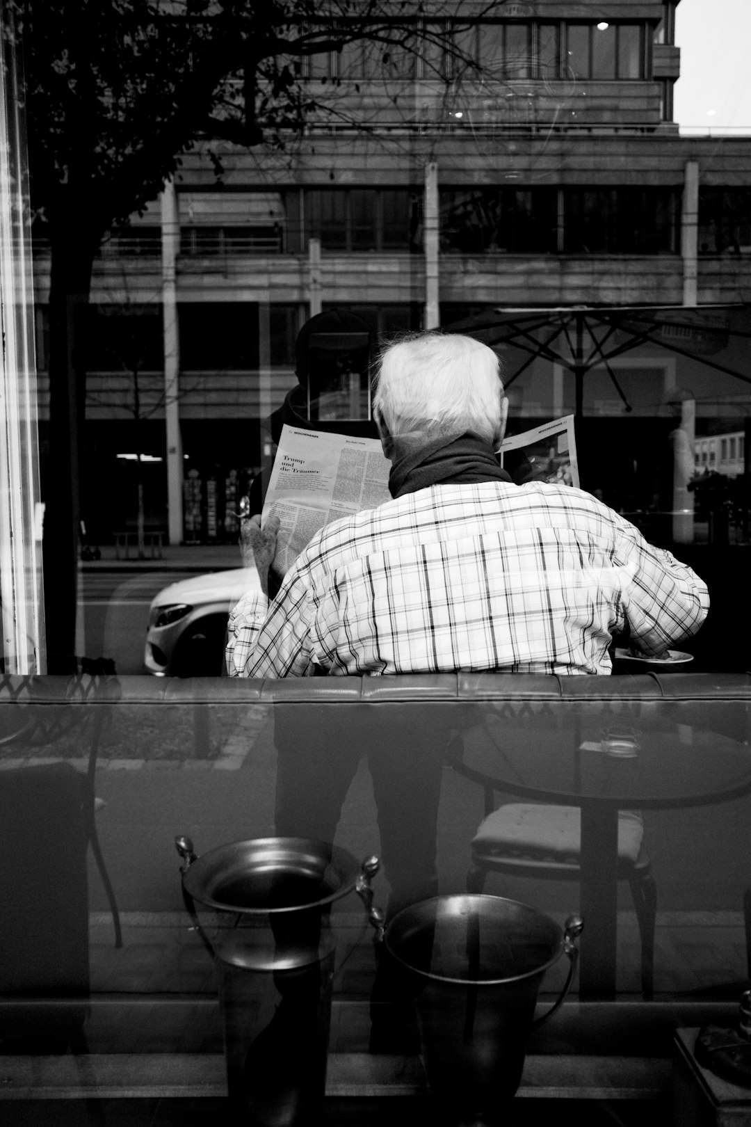 man in plaid shirt reading newspaper