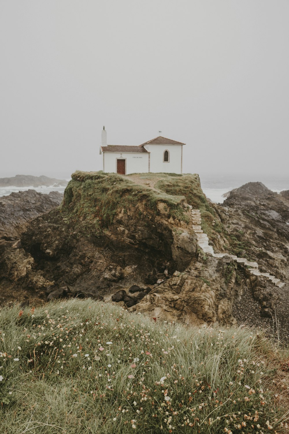 white concrete building on top of brown rock mountain