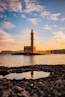 brown and white lighthouse near body of water during sunset