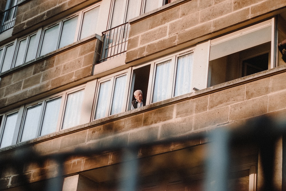 man in black jacket standing beside brown concrete building during daytime