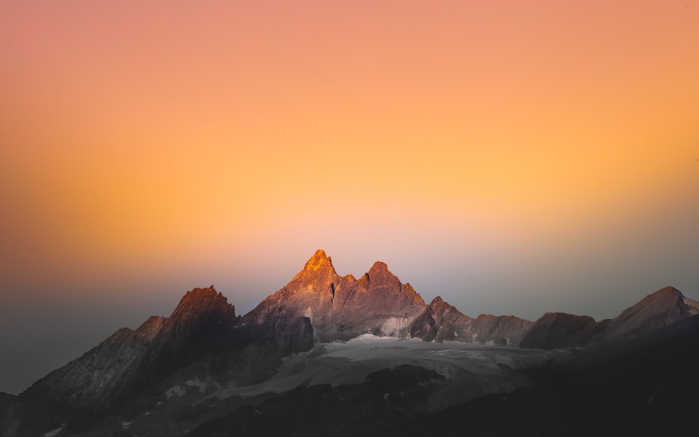 snow covered mountain during sunset