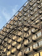 A completed modern industrial building with metallic gold accents gleaming under sunlight.