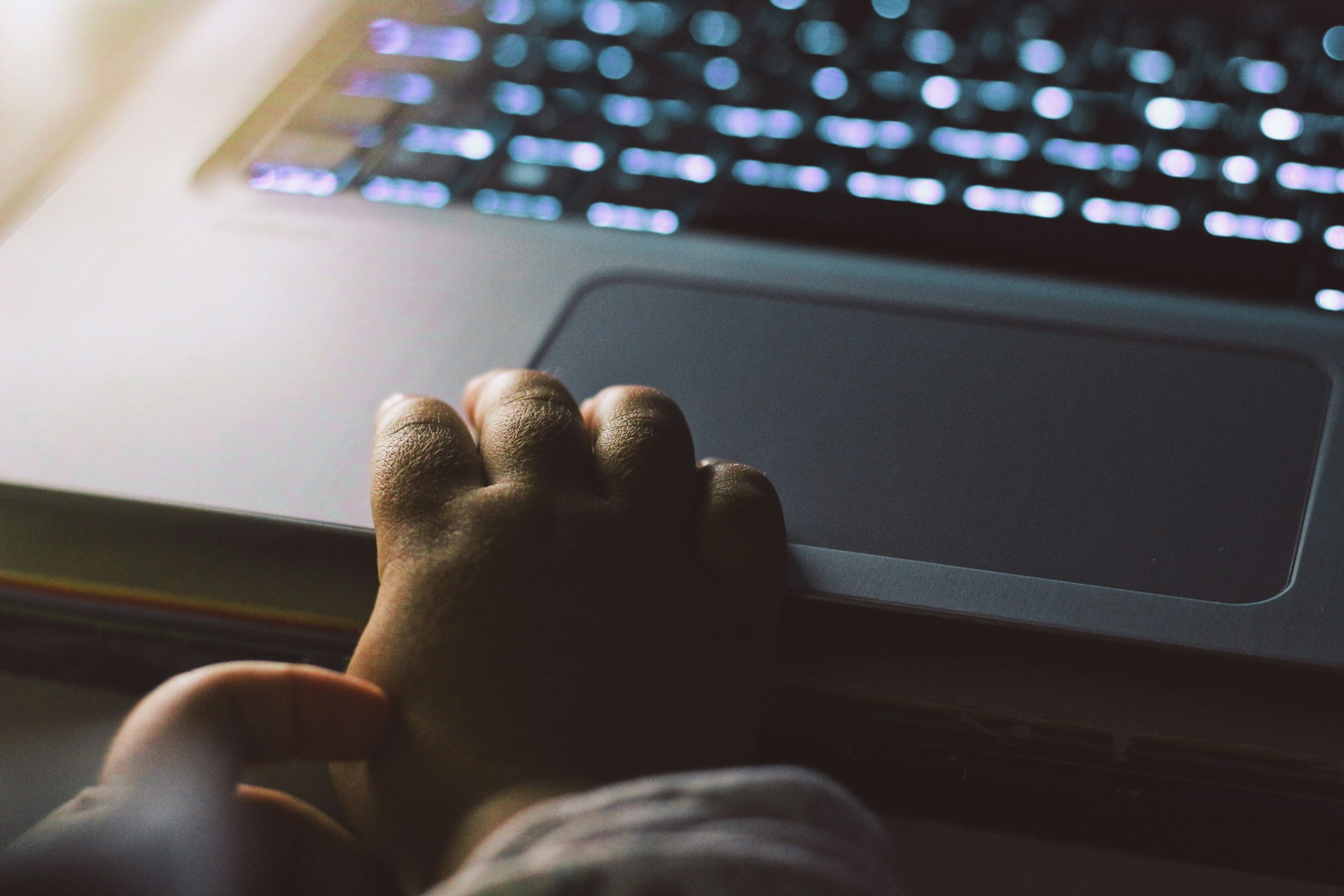 A child using a laptop with a parent gently guiding and watching nearby.