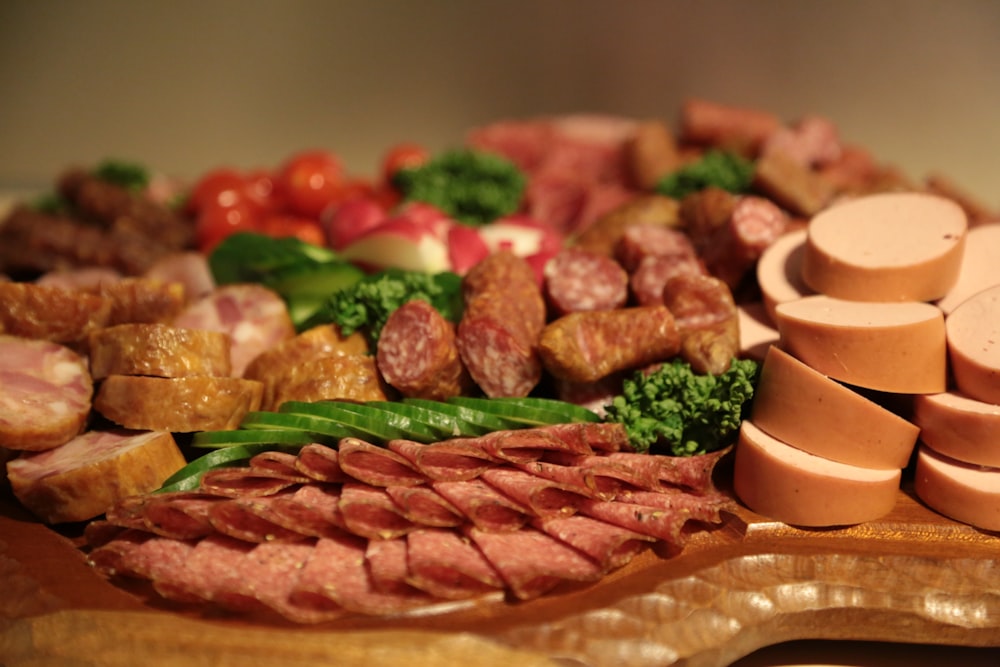 carne en rodajas con verdura verde en plato redondo de madera marrón