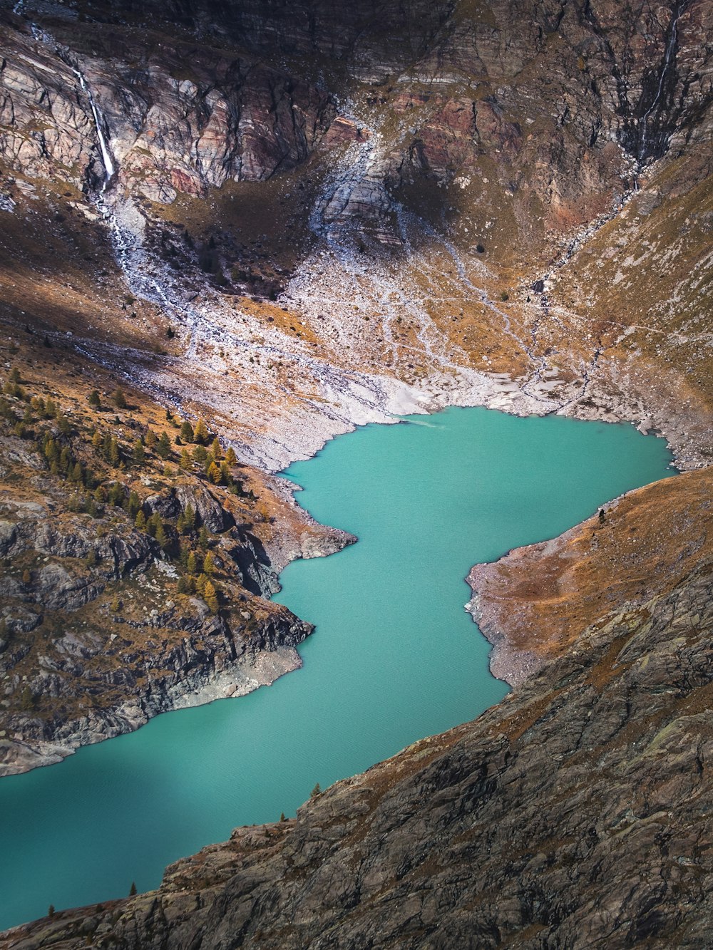 montagna rocciosa marrone e grigia accanto al fiume durante il giorno