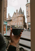Traveler enjoying a cup of coffee overlooking a European city square.