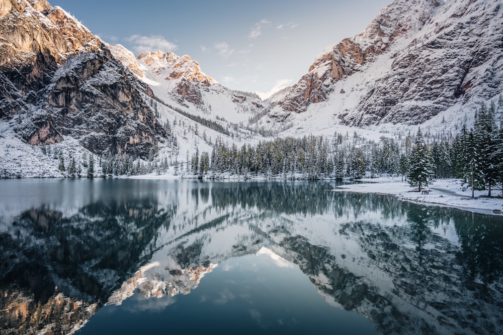 snow covered mountain near lake during daytime