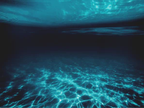 A sleek datlantis underwater data center module glowing softly beneath the deep blue sea.