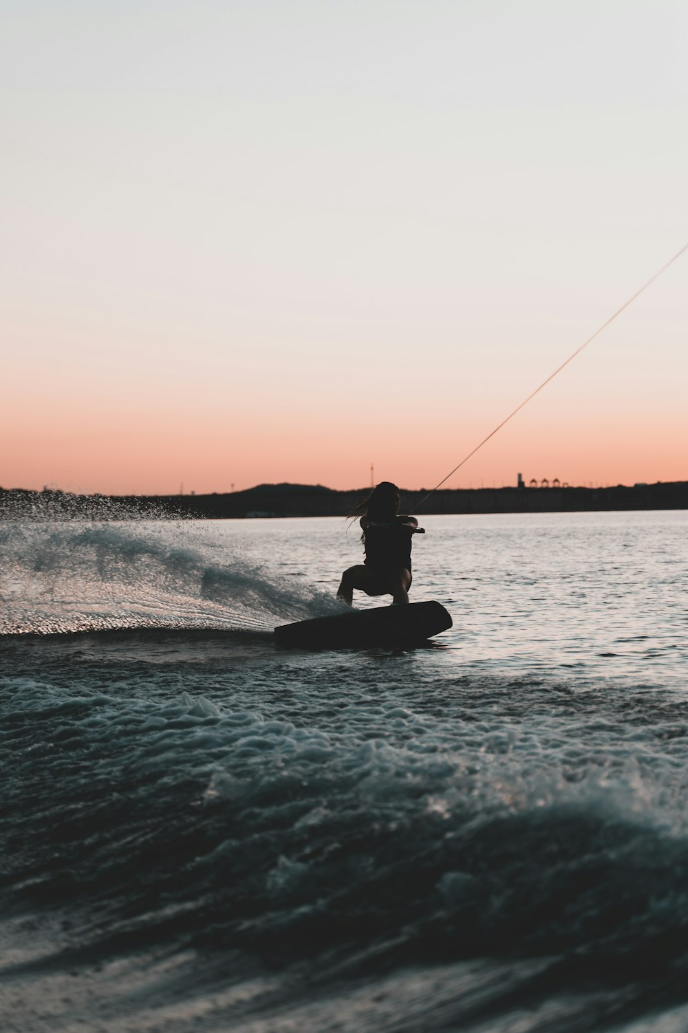 silhouette of man riding on boat during sunset