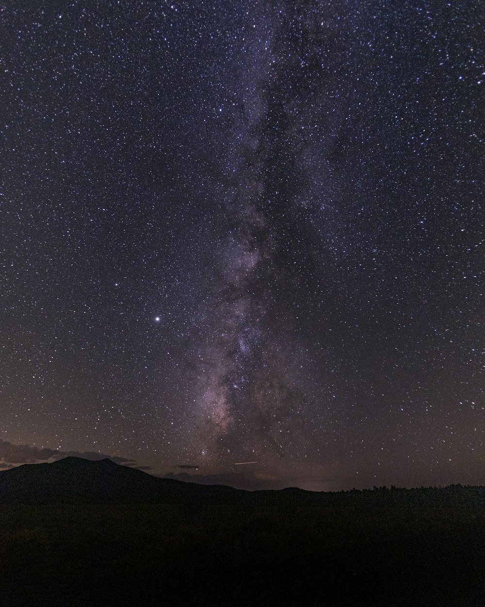 silhouette of mountain under starry night