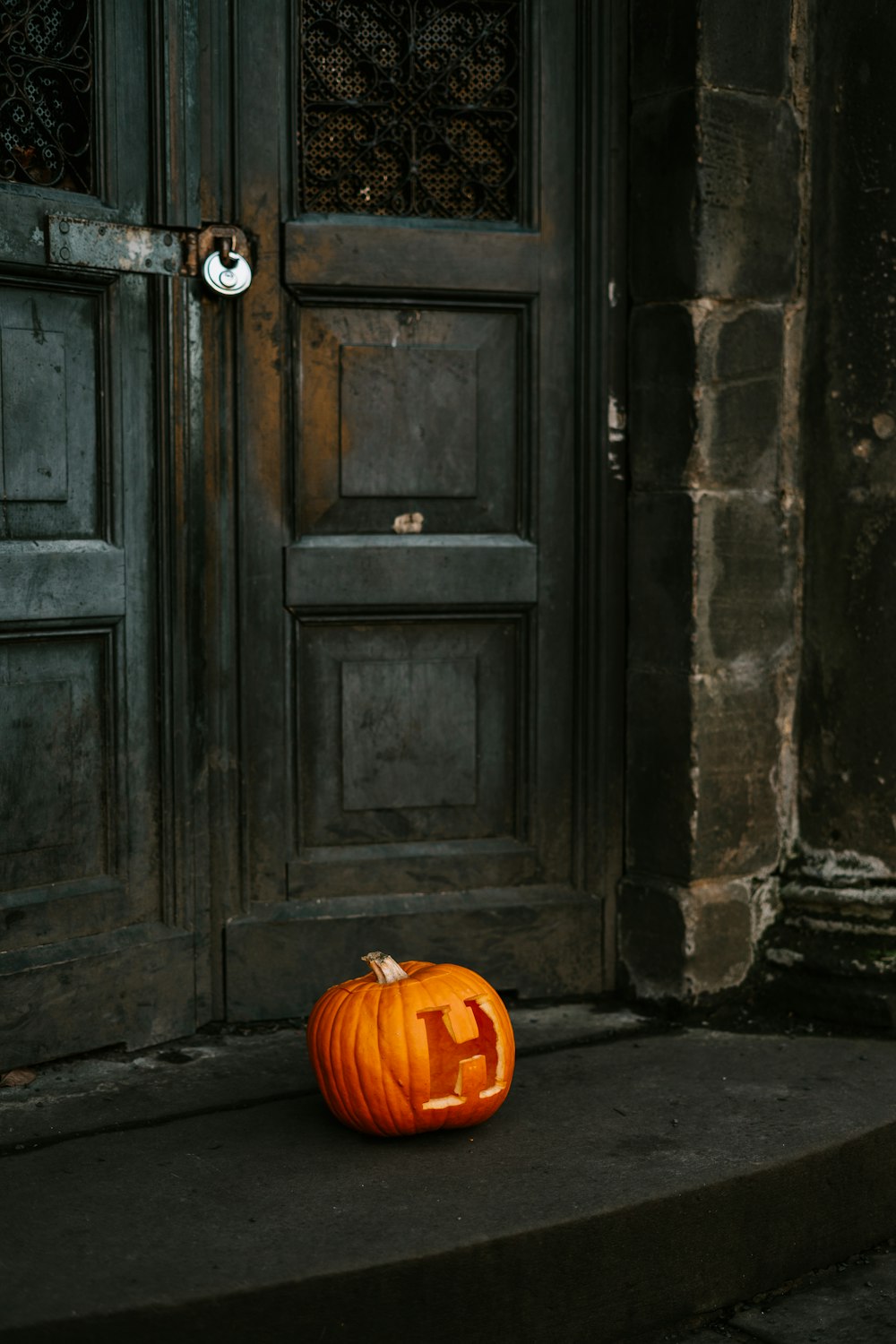 abóbora laranja perto da porta de madeira preta