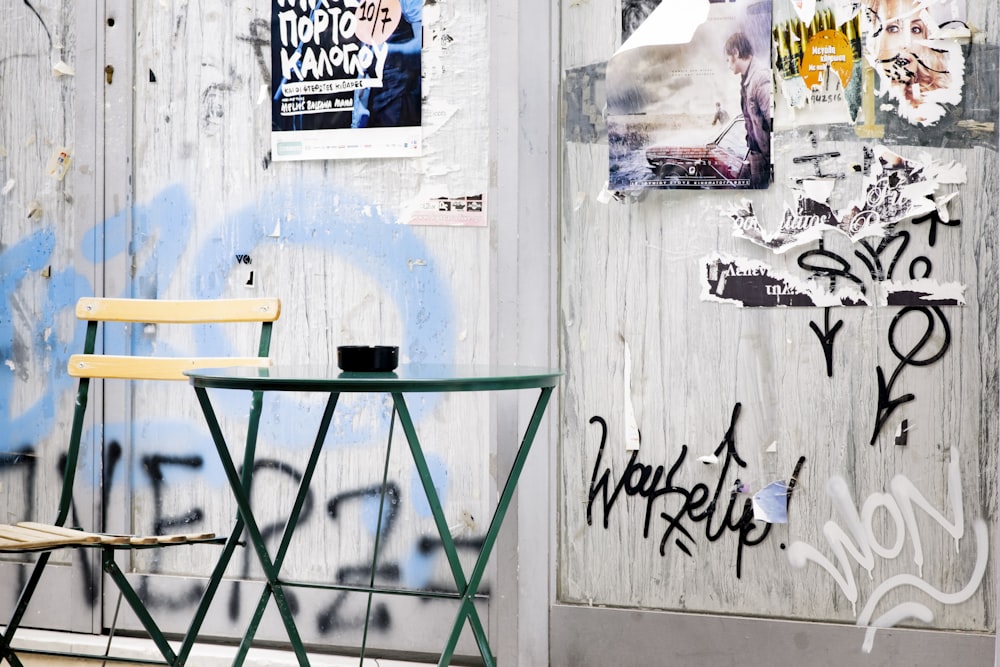 blue and green ladder beside white wall with graffiti