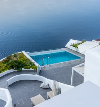 white concrete swimming pool near body of water during daytime