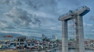 Construction workers inspecting a concrete bridge pier amid active site operations.