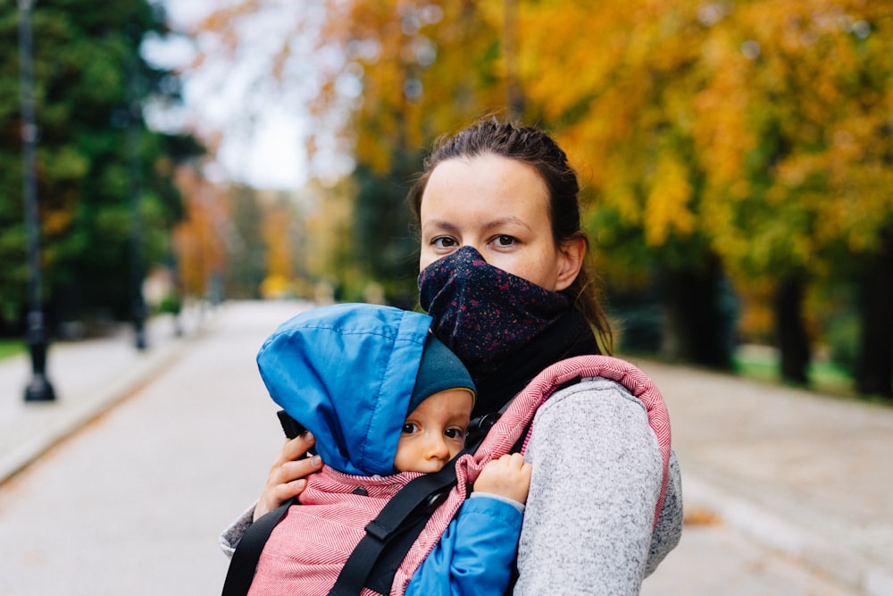 Junge in blau-rotem Kapuzenpullover mit blau-grauem Rucksack