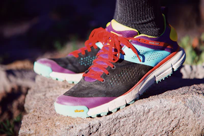 person wearing green orange and black nike athletic shoes