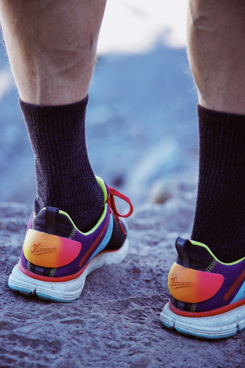 person wearing black and green socks and black and red nike athletic shoes