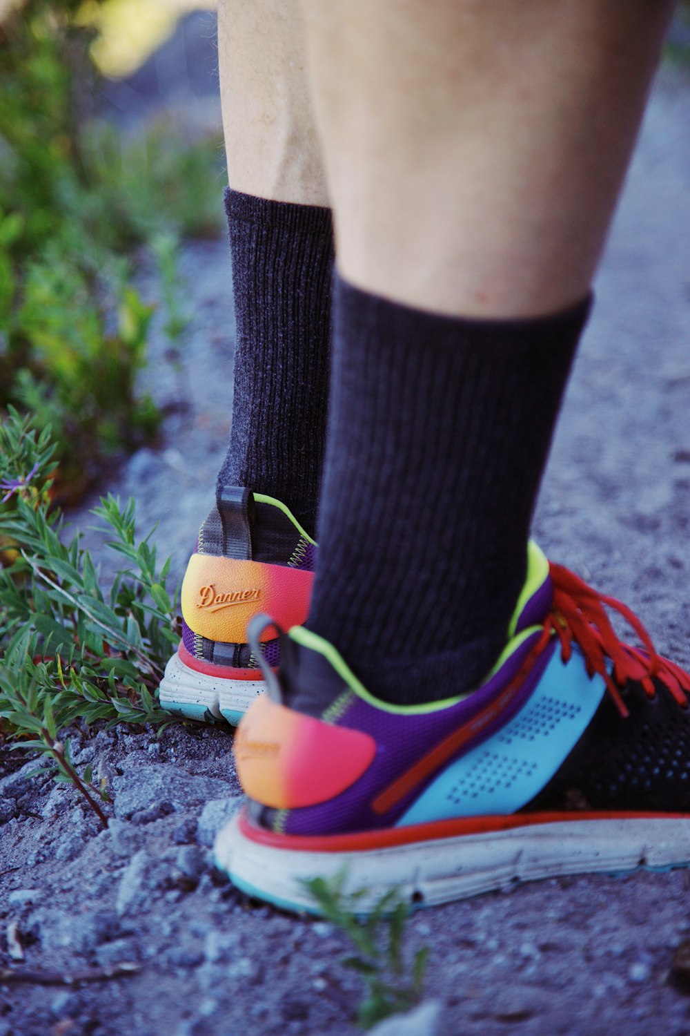 person wearing black and blue nike socks and orange and blue nike sneakers