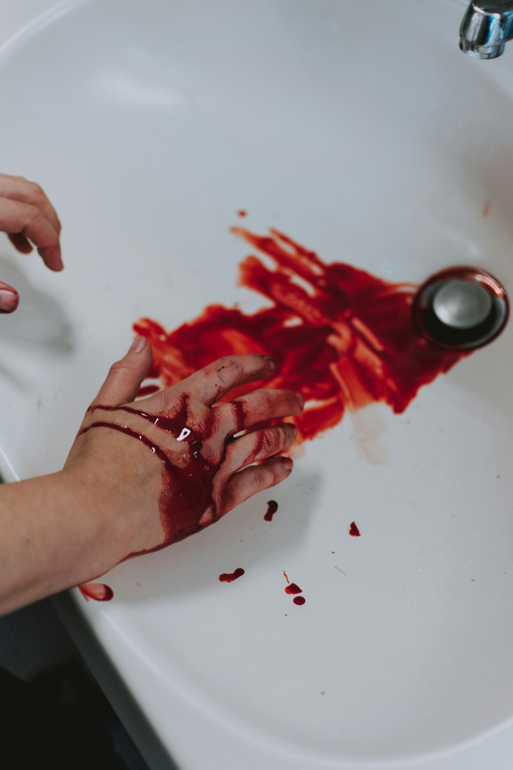 person holding red and silver round ornament