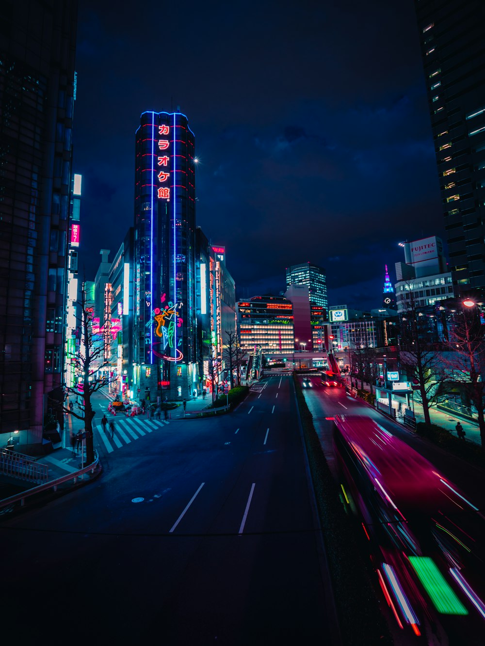 cars on road near high rise buildings during night time