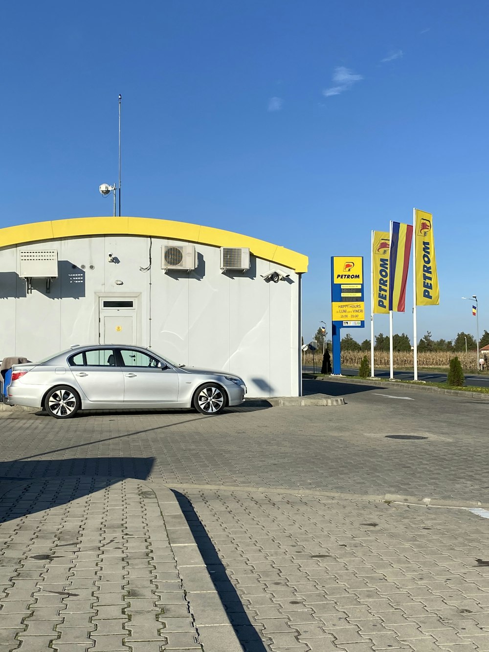 silver coupe parked beside white building during daytime