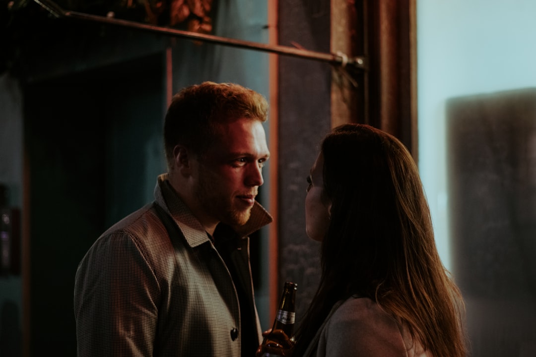 man in gray and white plaid button up shirt standing beside woman in white shirt