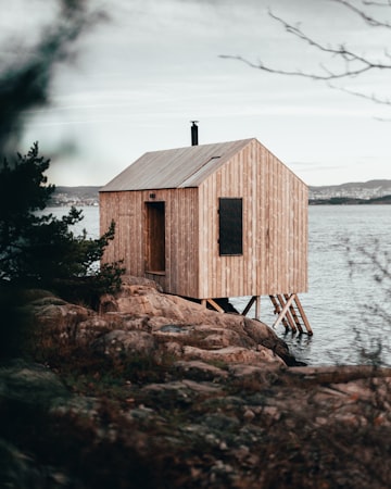 Small wooden cabin by waterfront