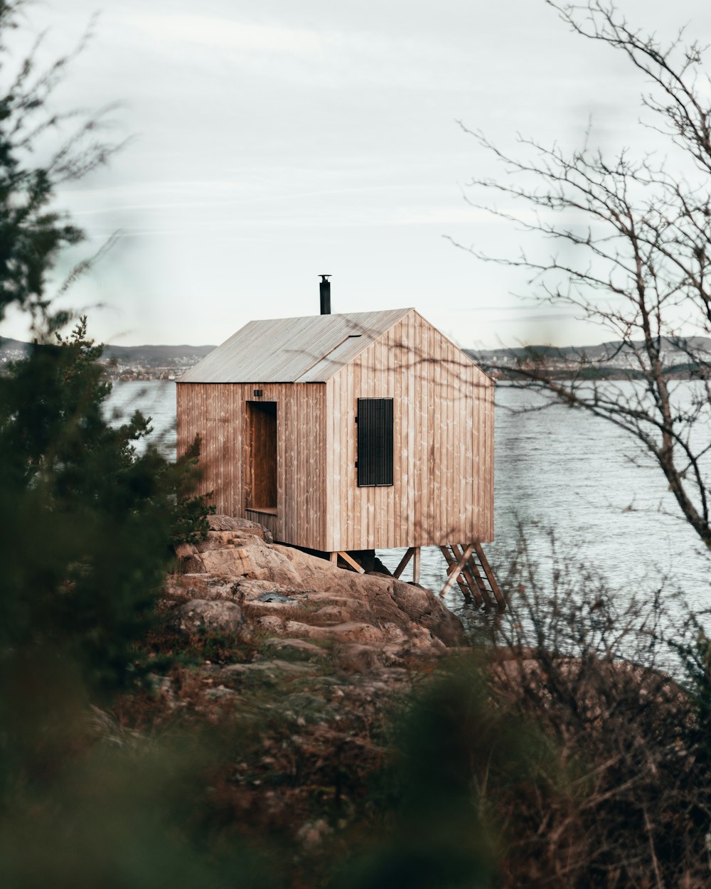 Maison en bois brun près d’un plan d’eau