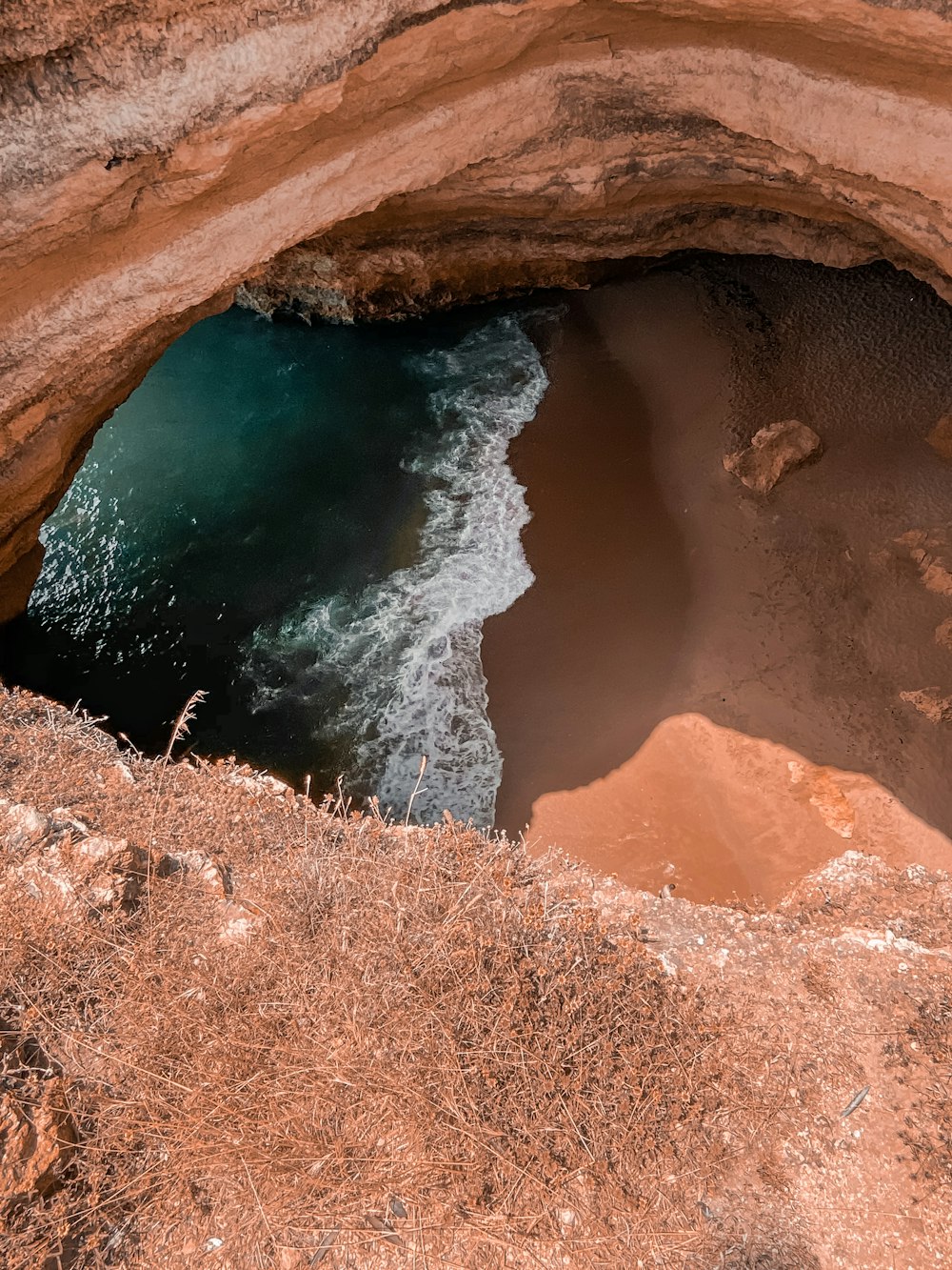 brown rock formation near body of water during daytime