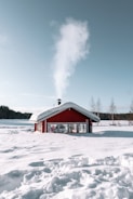 red and white wooden house on snow covered ground