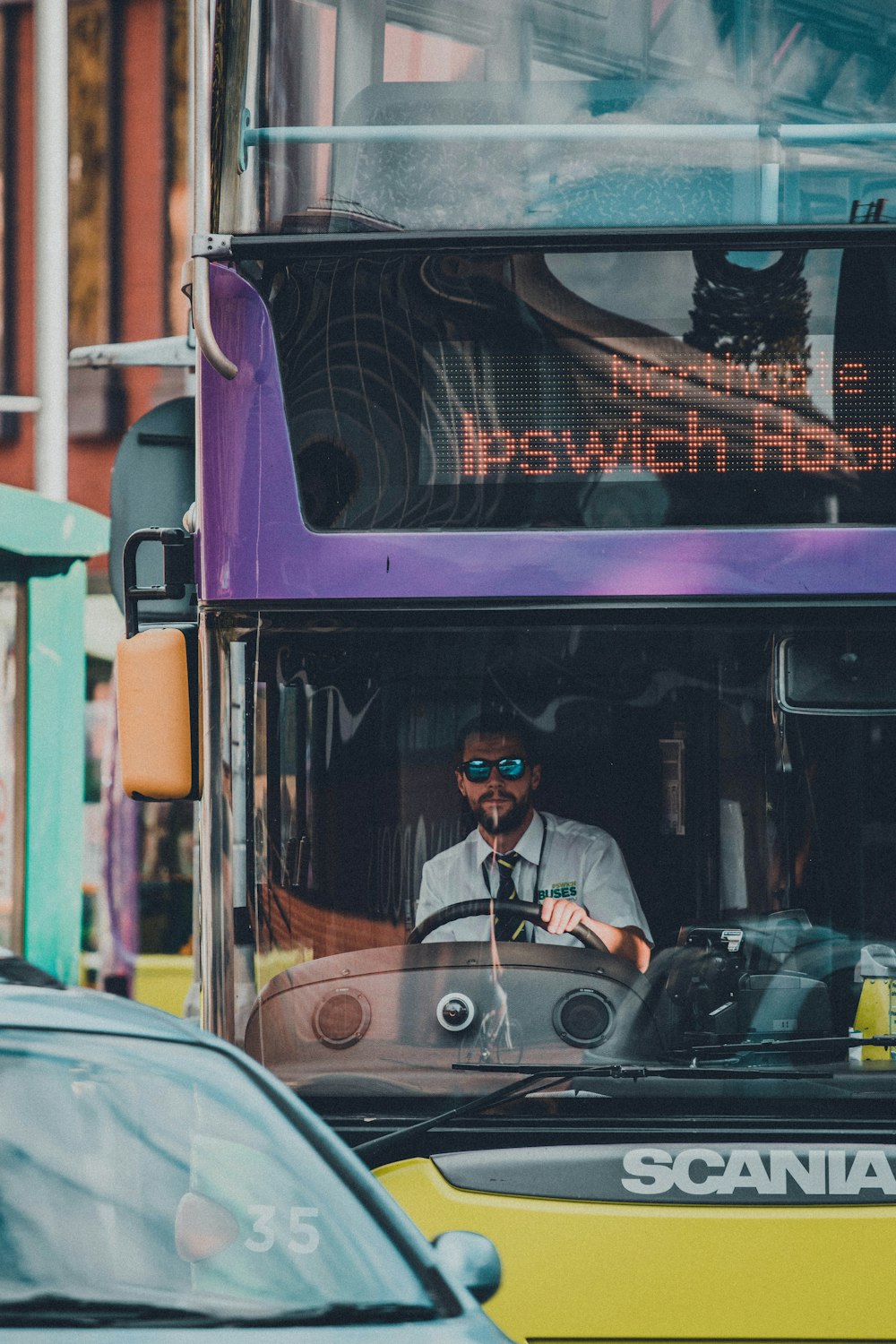 man in black jacket sitting on red bus during night time