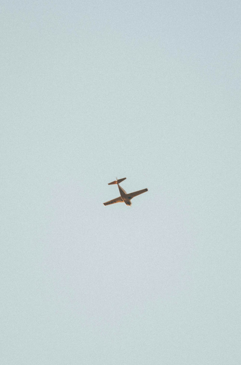 brown airplane flying in the sky