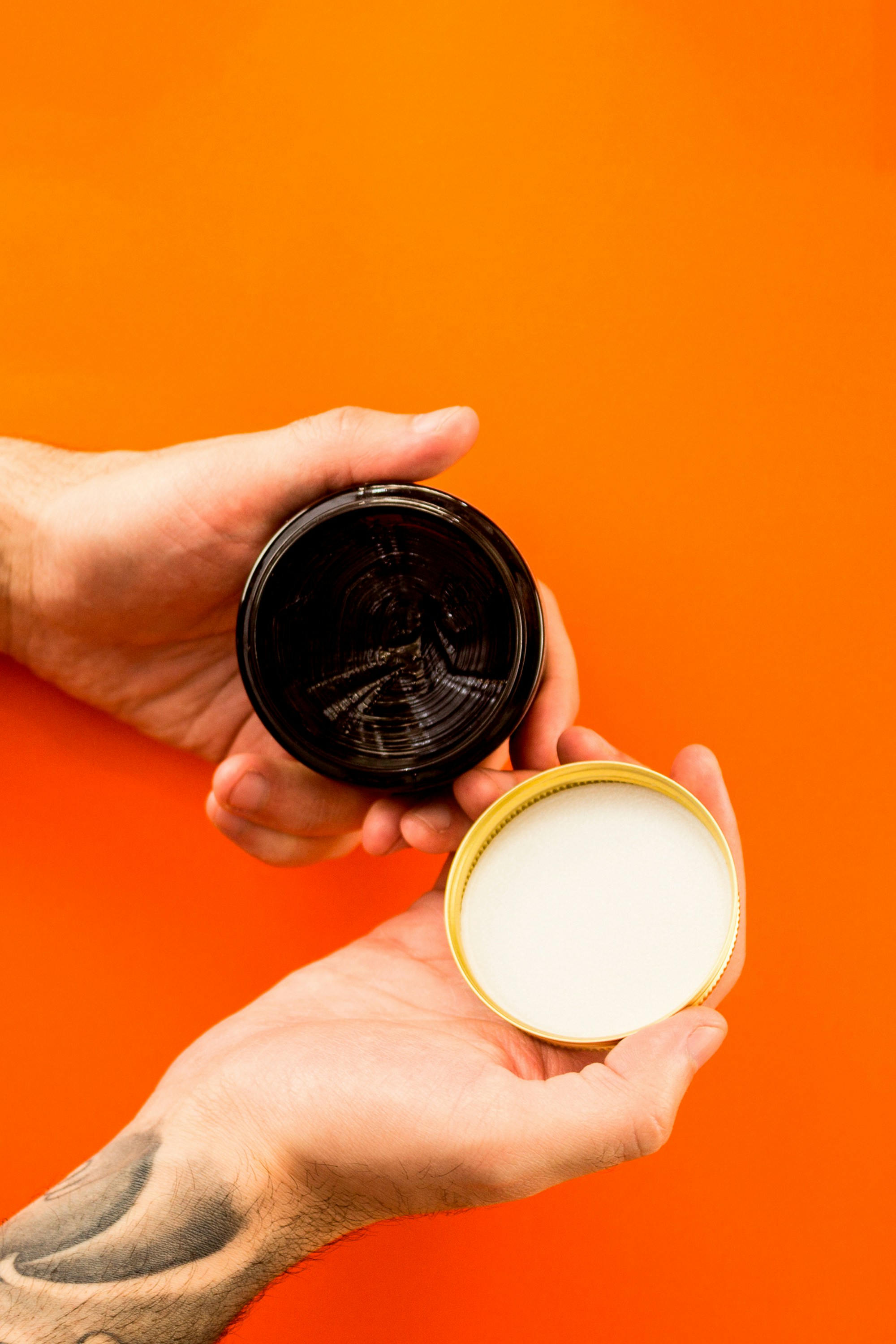 person holding black and brown round container
