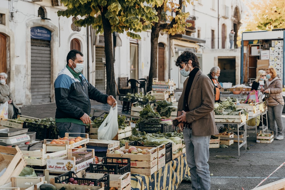 hombre con chaqueta verde de pie frente al puesto de comida