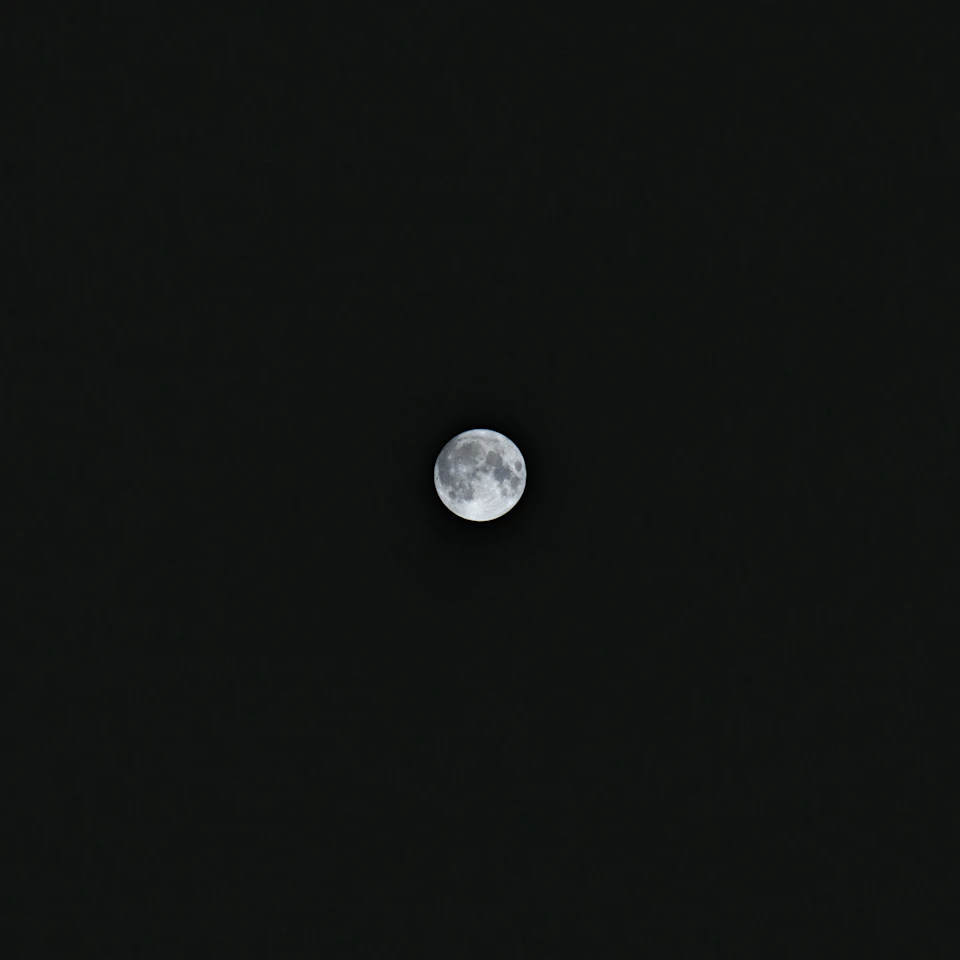 The image shows a full moon, round and bright, positioned centrally against a black sky. The moon is the sole object in the frame, with no other objects or distractions present. It appears to be a clear night, allowing for a perfect view of the moon's surface.