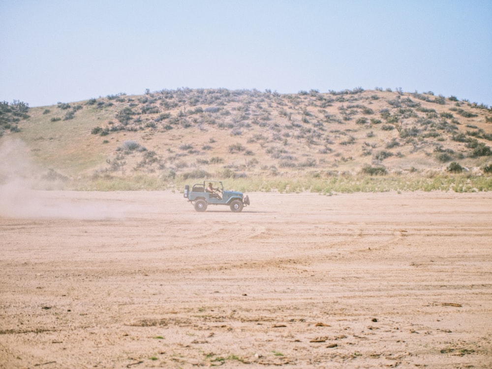 white car on brown field during daytime