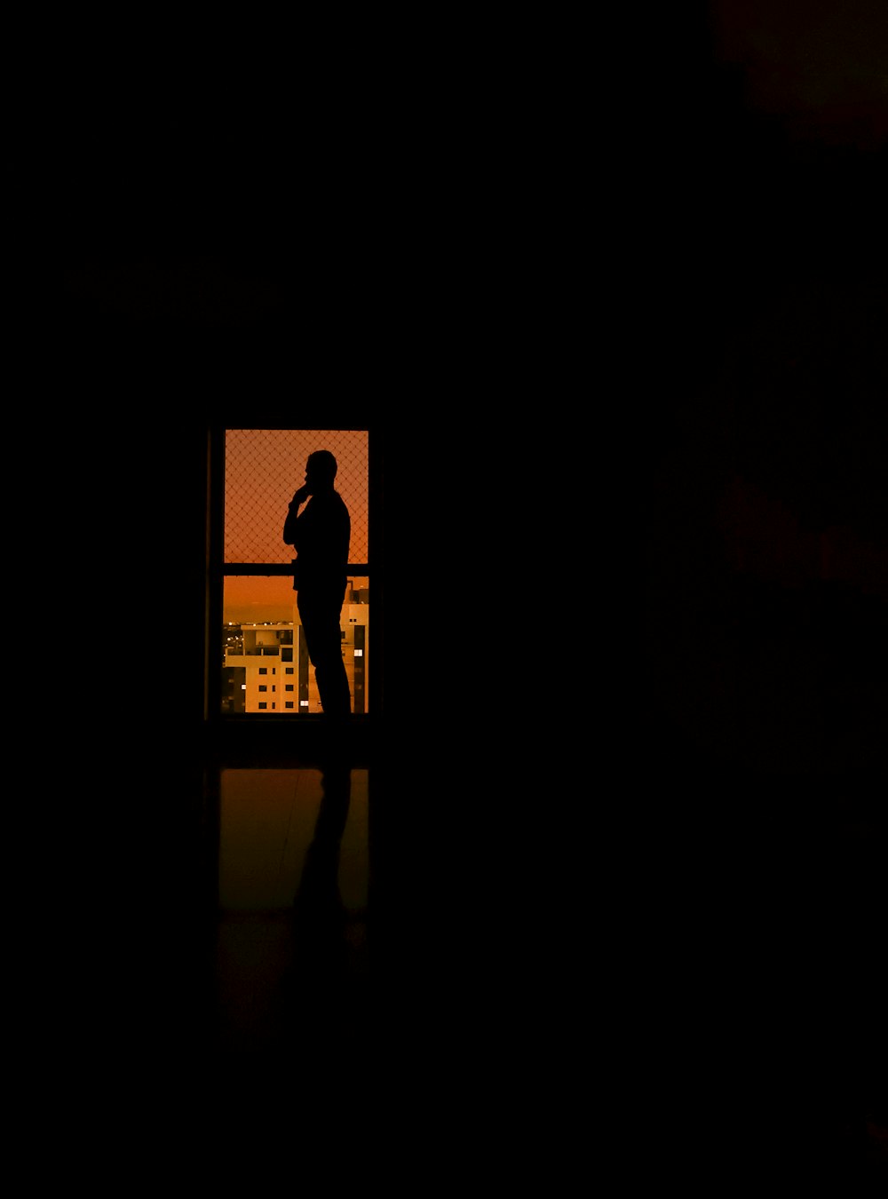 silhouette of woman standing in front of wall