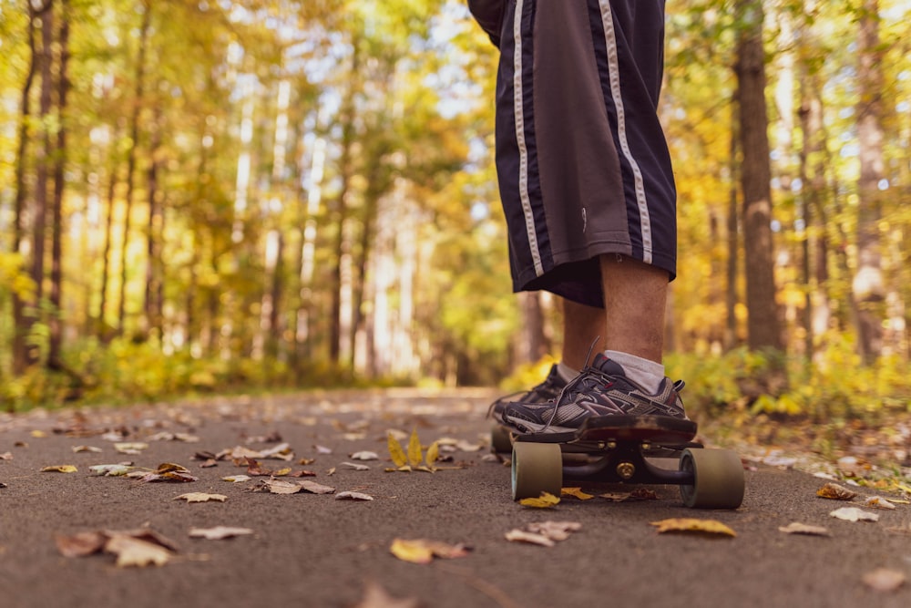 person in black pants and black shoes walking on the road