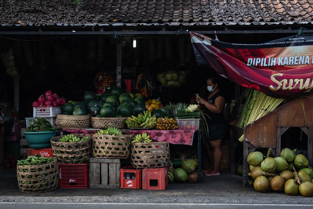 woman in black shirt standing near fruits