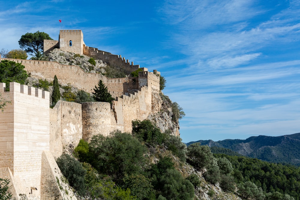 Castello di cemento marrone sulla cima della montagna durante il giorno