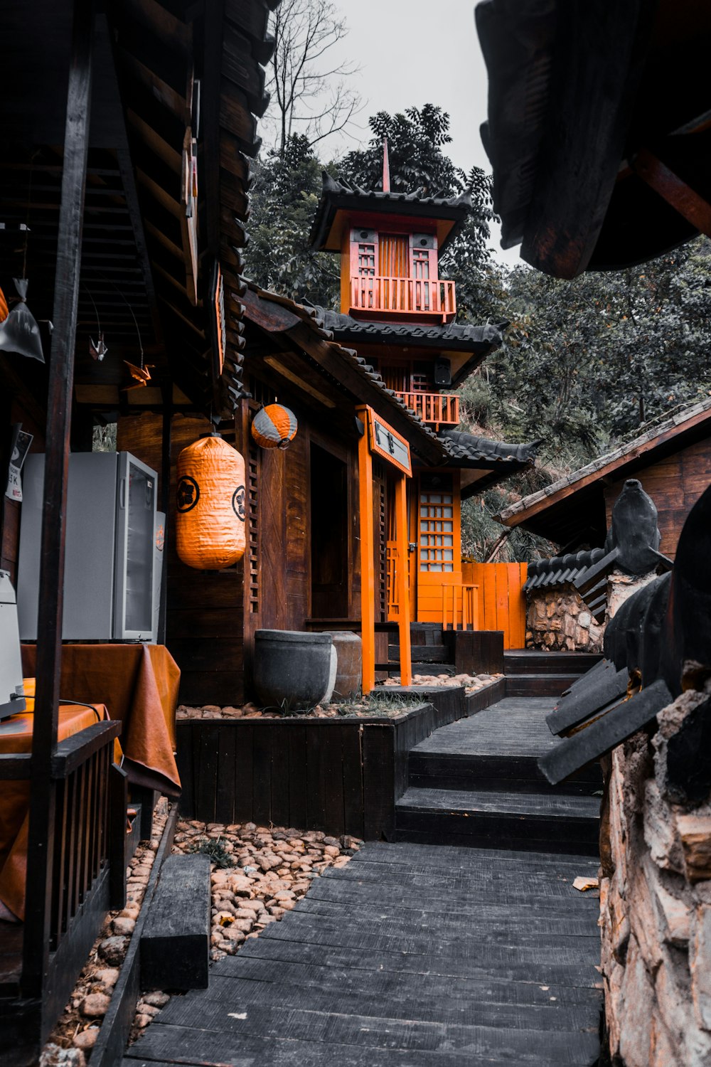 brown wooden house with gray concrete statue