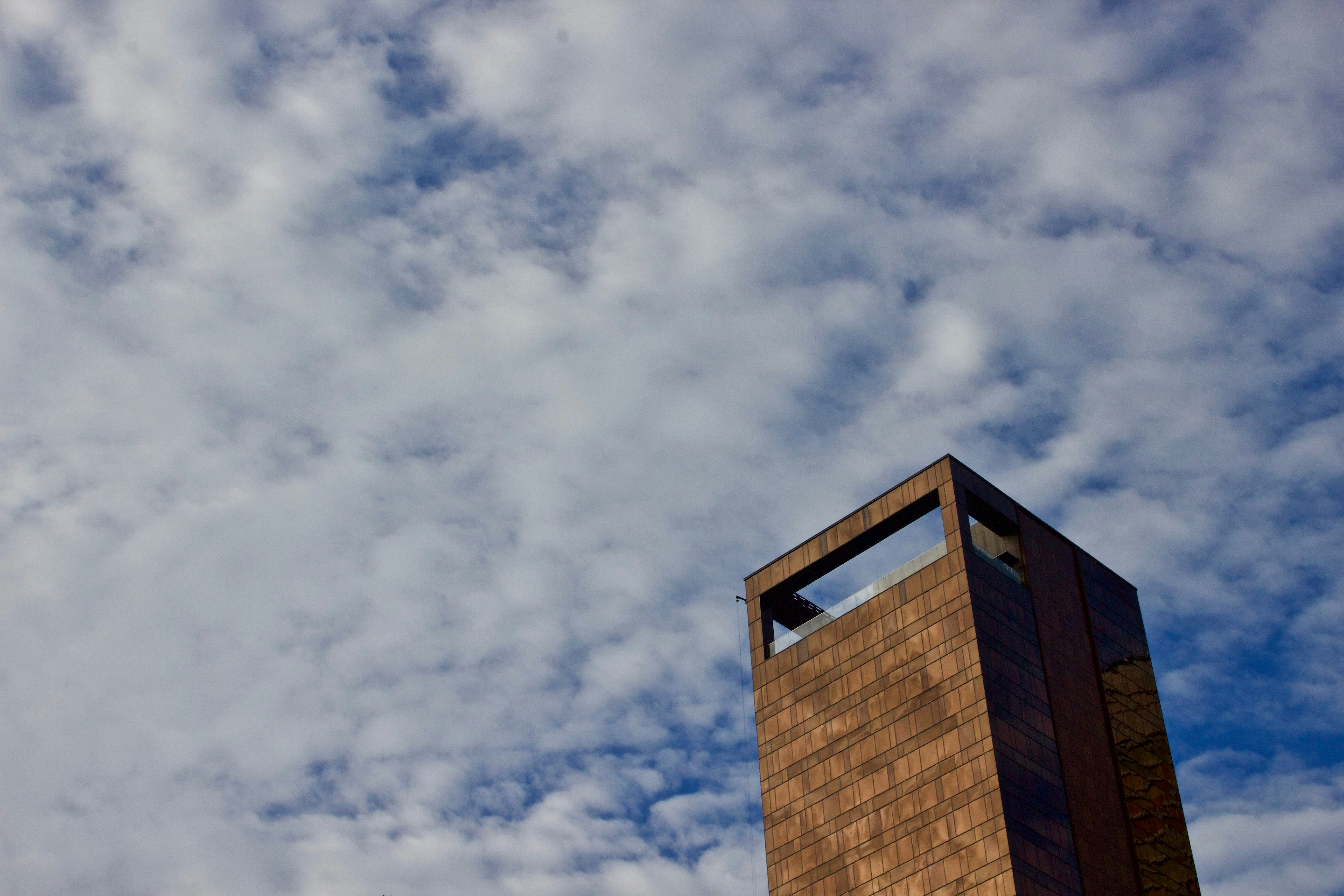 brown concrete building under white clouds during daytime