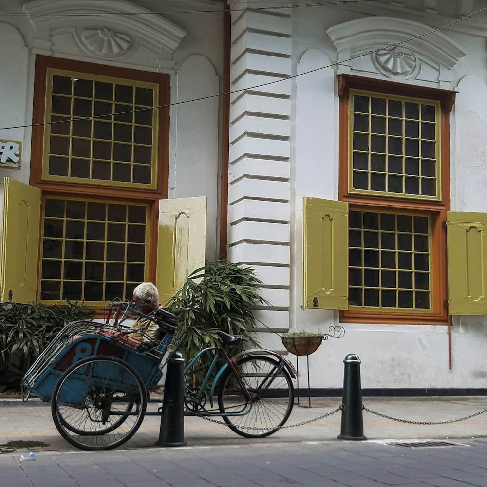 blue city bike parked beside white and brown concrete building during daytime