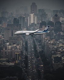 white airplane flying over city during night time