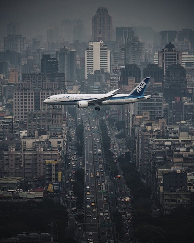 white airplane flying over city during night time