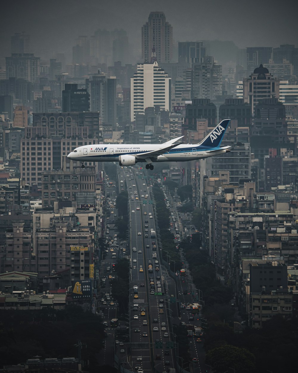 夜間に街の上空を飛ぶ白い飛行機