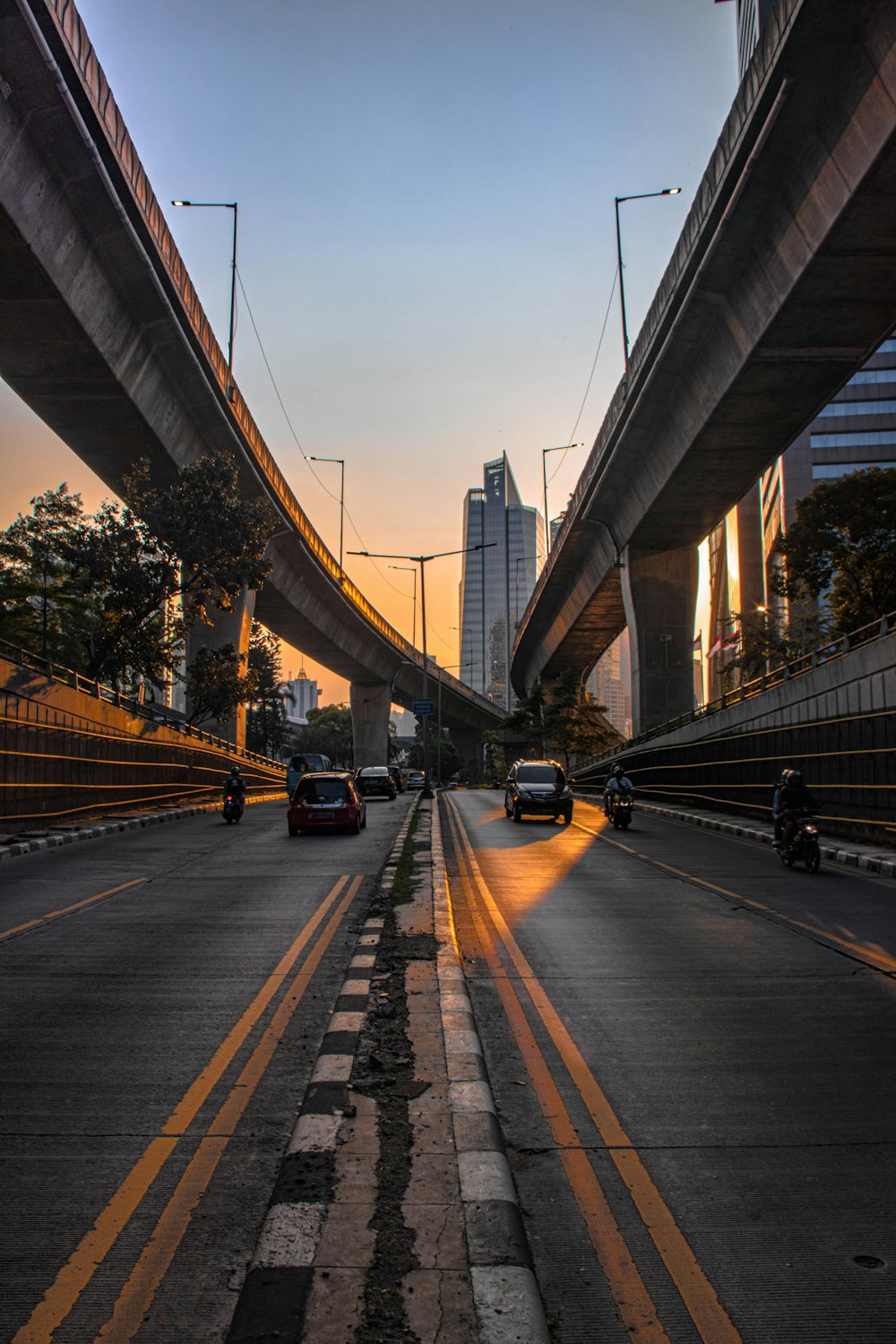 cars on road under bridge during daytime