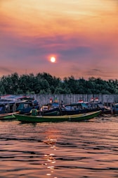 Colorful traditional boats docked at a vibrant Indonesian harbor at sunset.